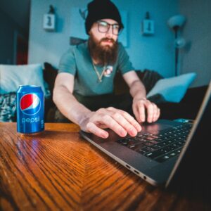 Man in Blue Polo Shirt Using Black Laptop Computer